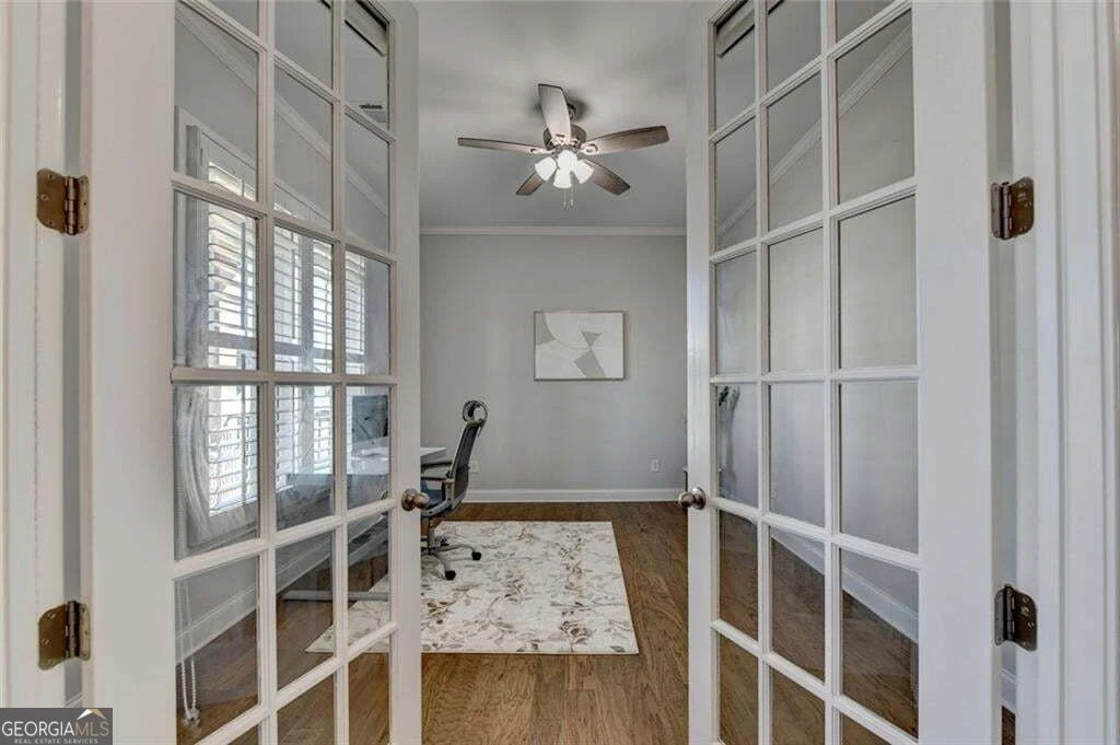 Room behind glass French doors, furnished with a desk