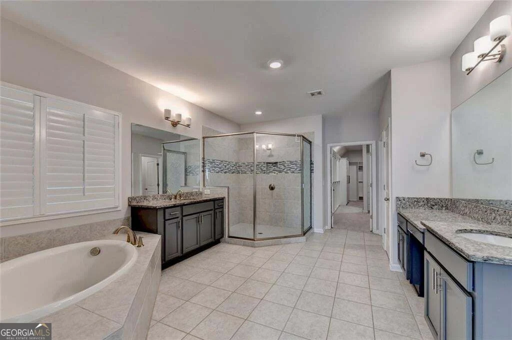 Bathroom with separate vanities, soaking tub and glass shower